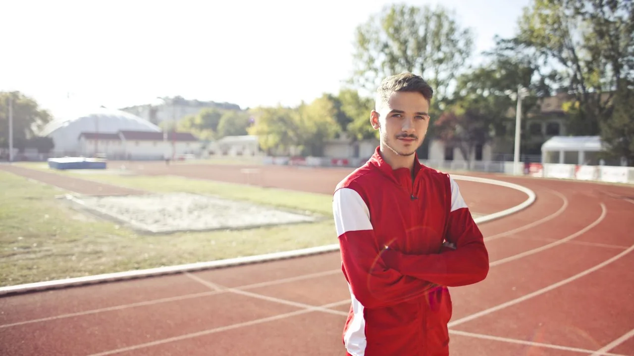 Biegacz na czerwonym torze lekkoatletycznym podczas treningu