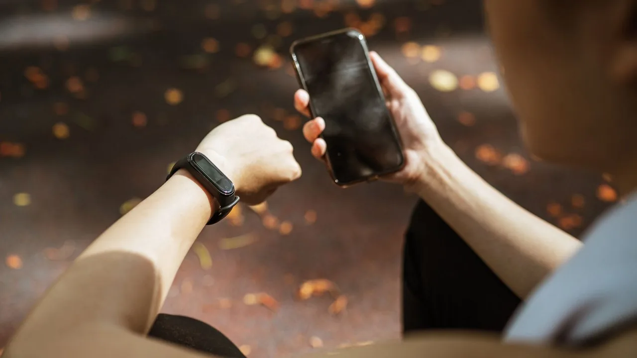 Ręka trzymająca smartfon z aktywną aplikacją do śledzenia biegu