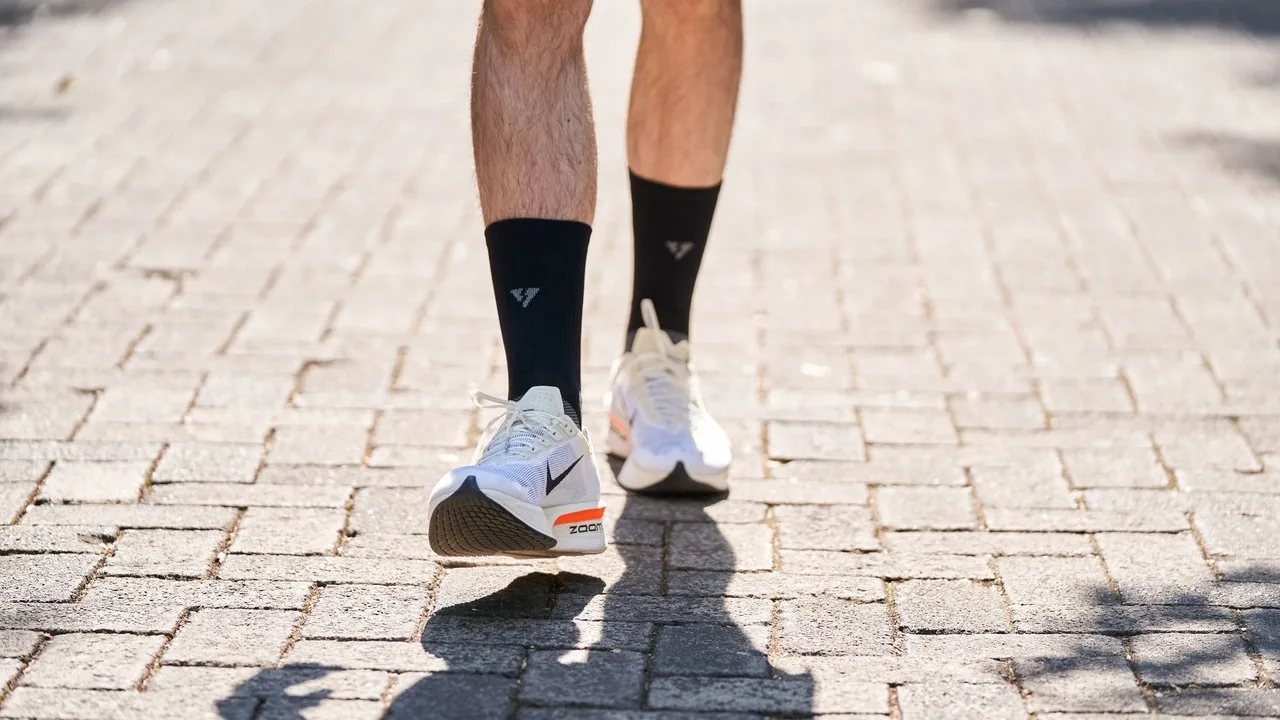 Zegarek sportowy na nadgarstku biegacza wyświetlający dane o tempie i spalonych kaloriach