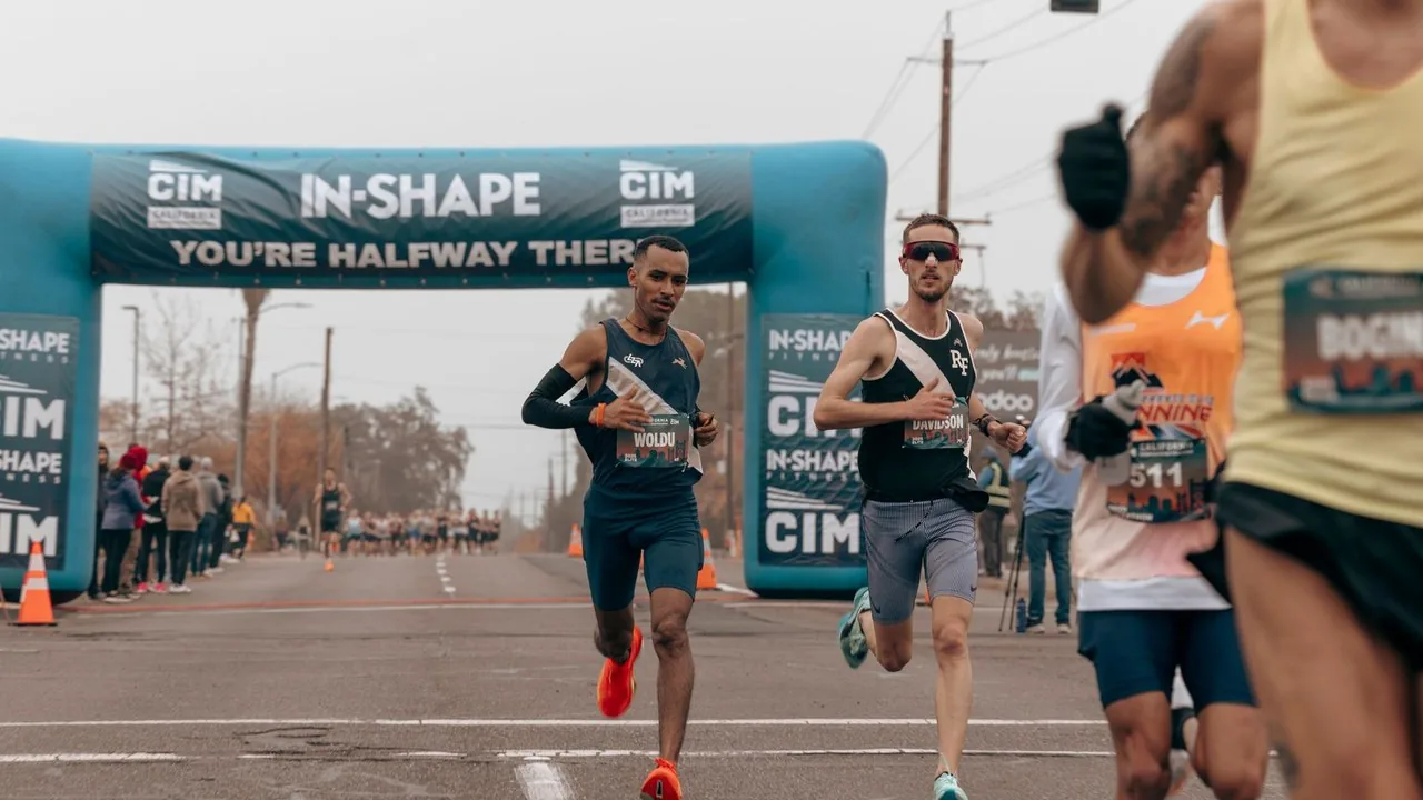 Biegacze przekraczają linię mety podczas maratonu na terenie targów